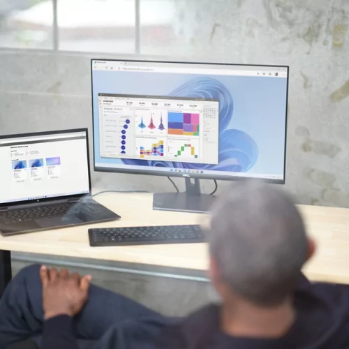 Man sitting in front of Desktop that features Power BI Dashboard