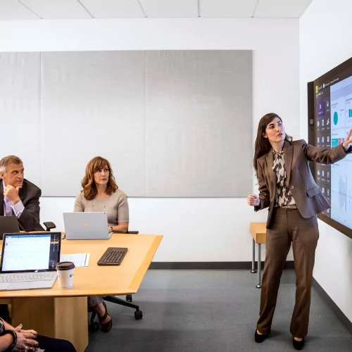 500x500px image of woman giving data analytics presentation using Power BI