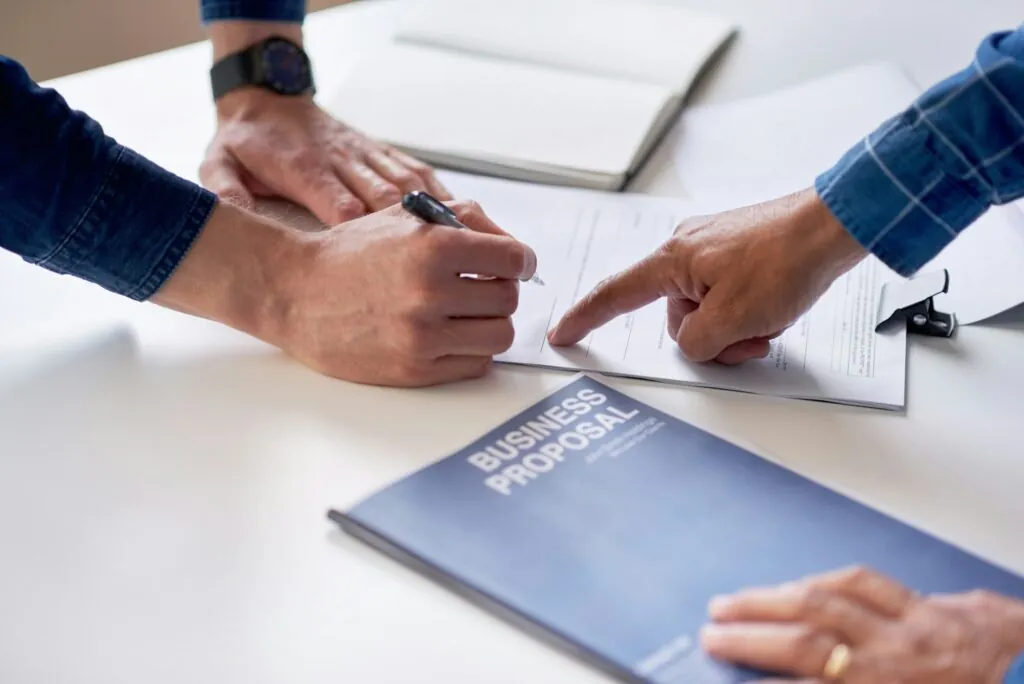 business people hands signing contract document for corporate partnership deal